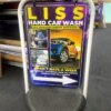 Double-sided outdoor pavement sign for car wash advertising, featuring a durable weather-resistant frame designed by Atlantic Design, used to display promotional messages and offers.