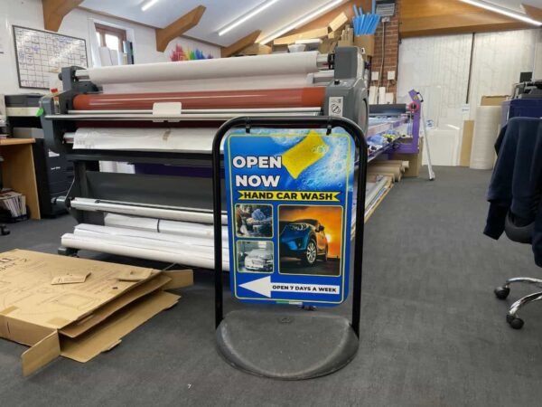 Double-sided outdoor pavement sign for car wash advertising, featuring a durable weather-resistant frame designed by Atlantic Design, used to display promotional messages and offers.